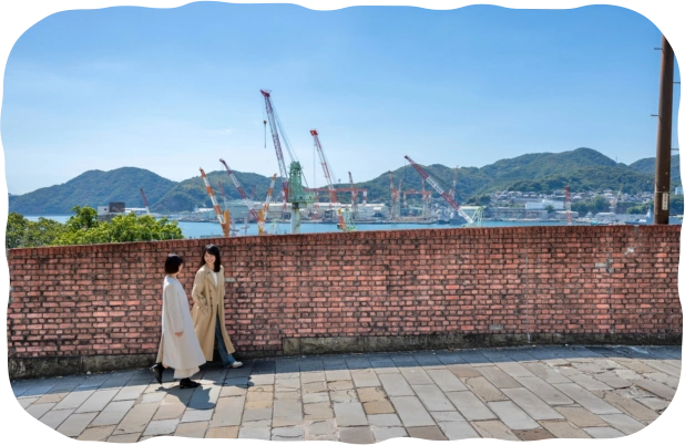 長崎港を望むオランダ坂を歩く二人