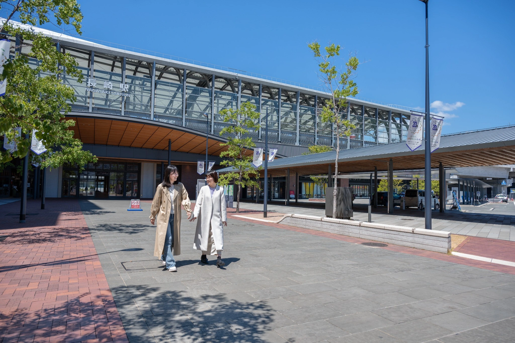 長崎駅のロングルーフの下を歩く二人